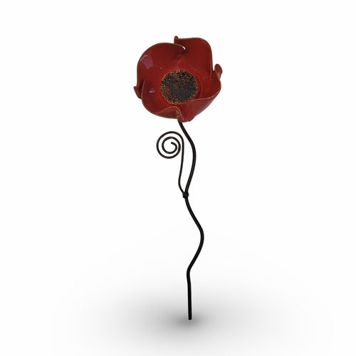 A single red flower-shaped ornament with a spiral design on a thin metal stem.