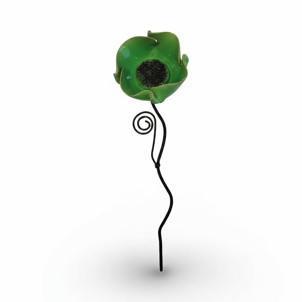 A green glass flower with a black center is shown against a white background.